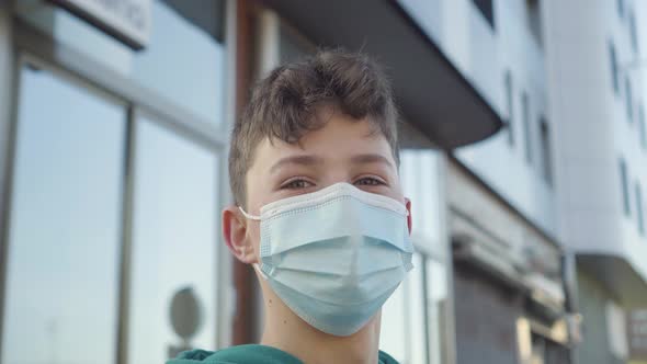 Portrait of a cheerful handsome young man in a medical disposable protective mask