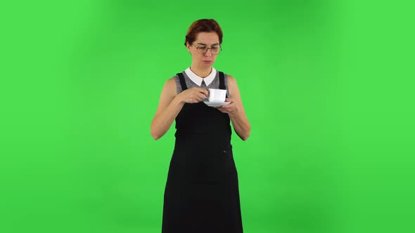 Funny Girl in Round Glasses Is Drinking Unpalatable Coffee. Green Screen