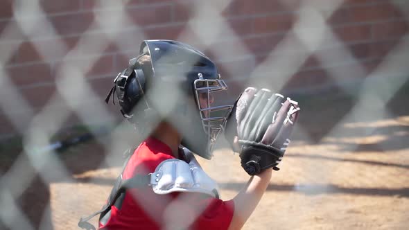 Close-up of a boy playing catcher for a little league baseball team.