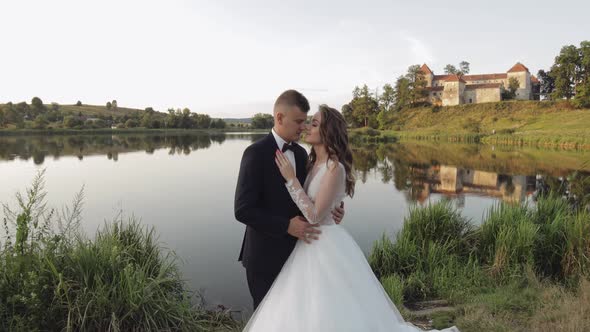 Caucasian Groom with Bride in the Park Near Lake. Wedding Couple. Newlyweds