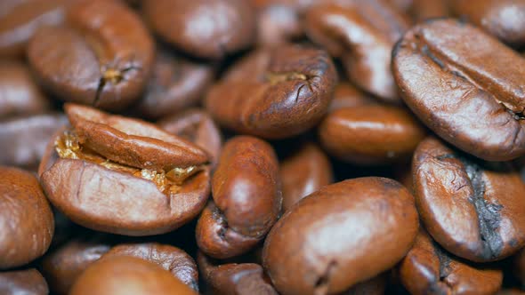 Roasted coffee beans dolly shot. Aromatic coffee beanse slowly. Slide slow motion close-up of whole