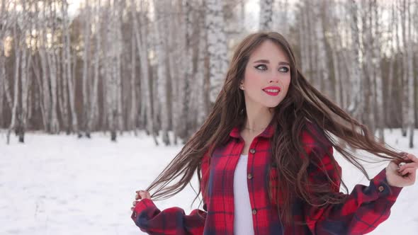 Charming Female with Long Hair Walking in Snowy Forest