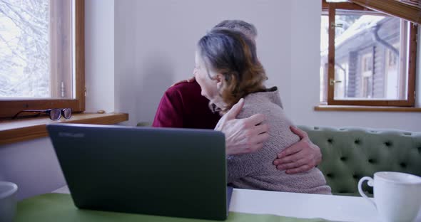 an Elderly Couple Husbands Wife Look at the Computer and are Happy About the Event or Because They