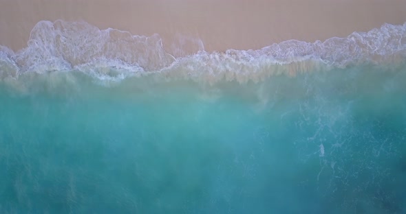 Luxury fly over abstract shot of a sandy white paradise beach and aqua blue ocean background in colo