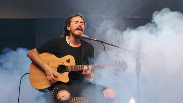 The Singer Plays an Acoustic Guitar and Sings at a Concert