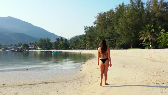 Ladies happy together on marine tourist beach adventure by shallow water with bright sandy backgroun