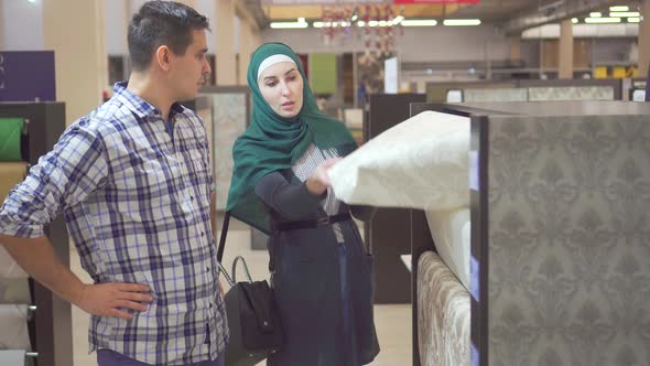 Young Muslim Couple Choose Wallpaper in the Store for Repair
