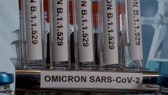 Close up tilt shot of a row of test tubes labelled with the new Covid 19 variant Omicron, the new mu