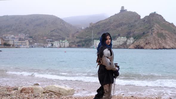 Woman Warrior in Armor Against Fortress on Rock and Sea