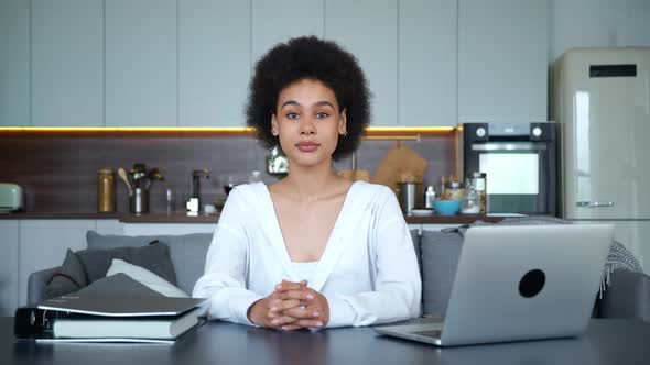 Confident Portrait of African American Young Freelance Woman Working at Home Sitting at Table with