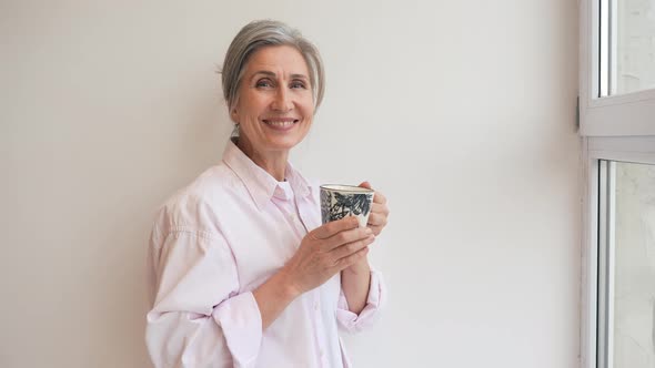 Portrait of Elderly Female in Casual Casual Wear Holding a Mug