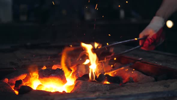 Burning Coals Are Getting Beaten with the Tongs