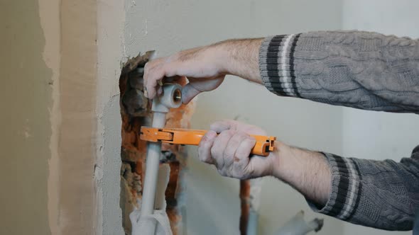 Close Up of a Plumber Cuts a Pipe for Water Supply