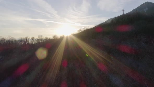 Aerial Drone Flight Establisher Over Snowy Forest Woods at Sunset