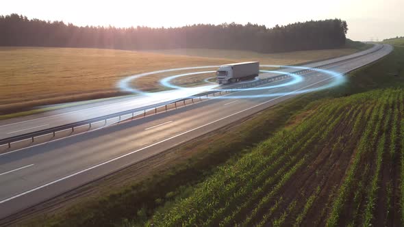 Aerial view of a self-driving autonomous delivery truck moving along the highway.