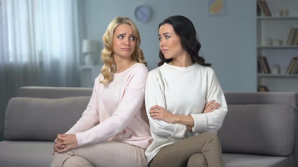 Female Friends Sitting on Sofa at Home, Hugging and Reconciling After Quarrel