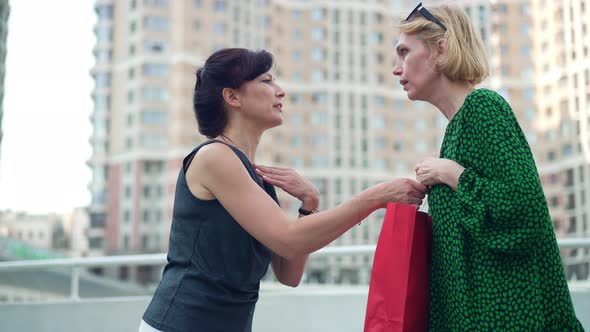 Side View Two Women Fighting for Shopping Bag on City Street Outdoors