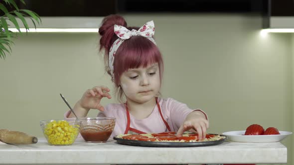 Cooking Pizza. Little Child in Apron Adding Sliced Tomatoes To Dough in Kitchen