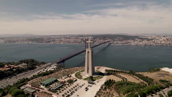 25 de Abril bridge connecting Almada to Lisbon. Sanctuary Christ the King overlooking Tagus river.