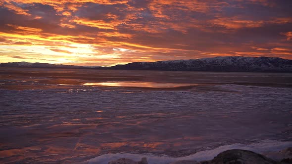 Panning over frozen Utah Lake during colorful sunset