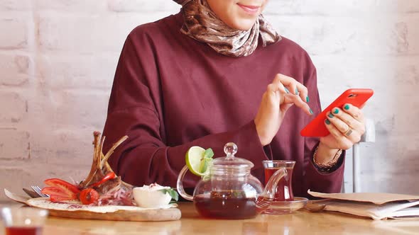 Muslim Business Woman Working on Mobile Phone in Cafe