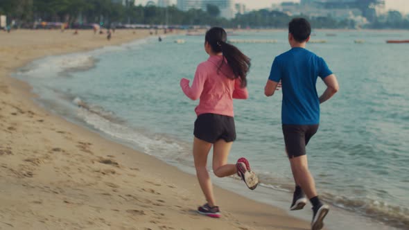 Runners fitness couple running training on the beach.