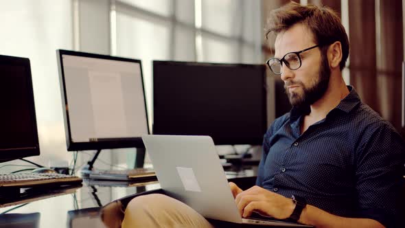 Salesman Analyzing Charts On Laptop.Focused Trader Reading Corporate Financial Audit Report Document