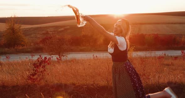 Beautiful Slavic Girl in Dress Poses at Camera with Two Pints of Beer on Nature