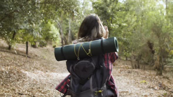 Young Backpacker Girl with Camera Taking Pictures of Forest