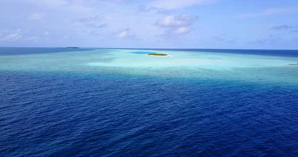 Wide angle above island view of a white sandy paradise beach and aqua blue ocean background