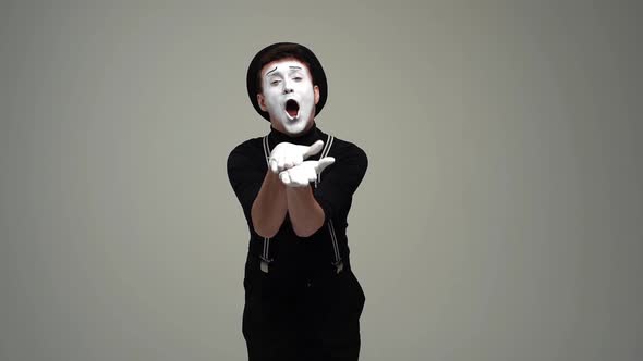 Portrait of Happy Male Mime Bowing in Gratitude and Applauding Looking at Camera