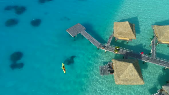 Aerial drone view of a man and woman couple on a tandem sea kayak in Bora Bora tropical island