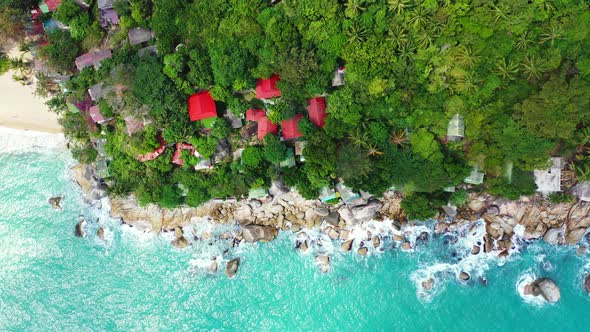 colorful roofs of the bungalows on the cliff edge of Koh Phangan. Aerial vertical background