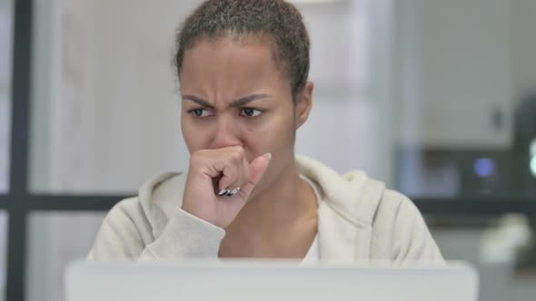 Close Up of African Woman Coughing While Using Laptop