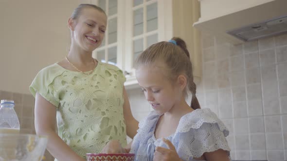 Portrait Young Woman and Her Little Daughter Cooking Cake at Home in the Kitchen