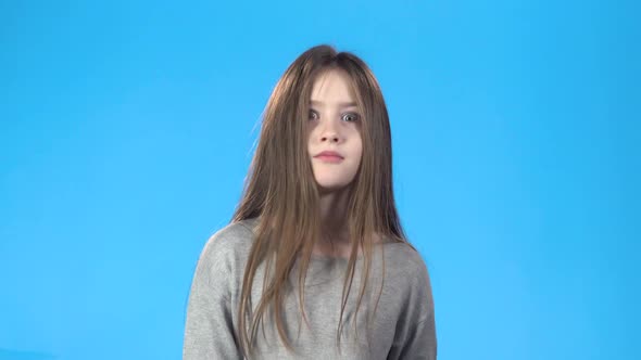 Teenage Kid Acting Like She Amazed Posing Against Blue Background.