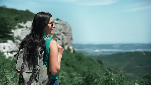 Hipster Female with Backpack Admiring Nature Landscape on Top of Mountain