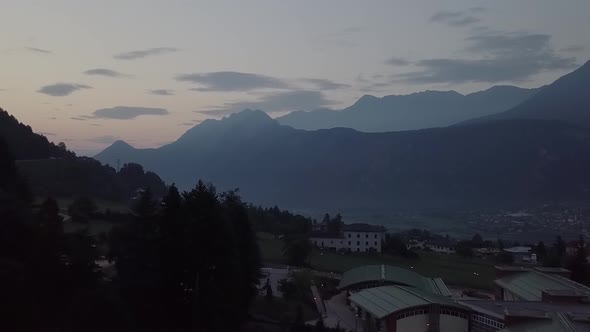 Aerial view of Levico Terme, Italy during sunrise with drone flying forward