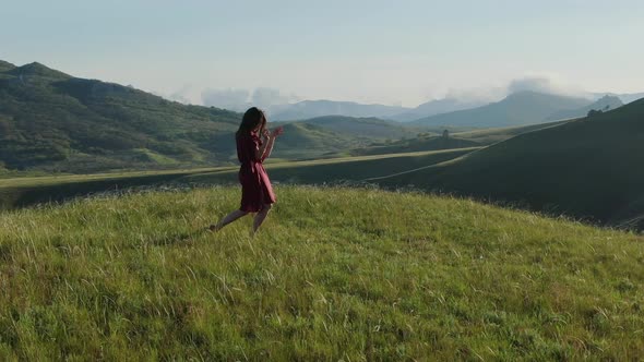 Aerial View and Circular Panorama Around a Young Modern Shaman Woman Who Dances a Dance of Power in