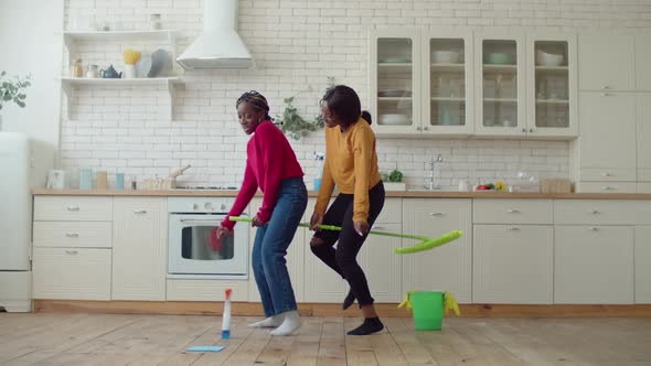 Excited Black Teenage Girls Riding on Mop During Housework