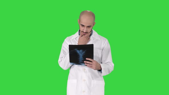 Doctor Examining a Lung Radiography While Walking on a Green Screen, Chroma Key.