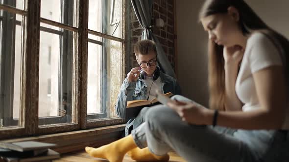 Two Students Studying Through Book and Smartphone