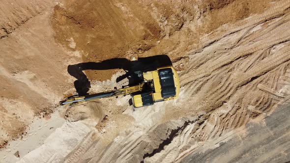 Aerial top view of an excavator working at a construction site.