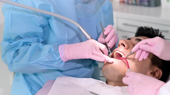 Female Dentist Examining a Patient with Tools in Dental Clinic