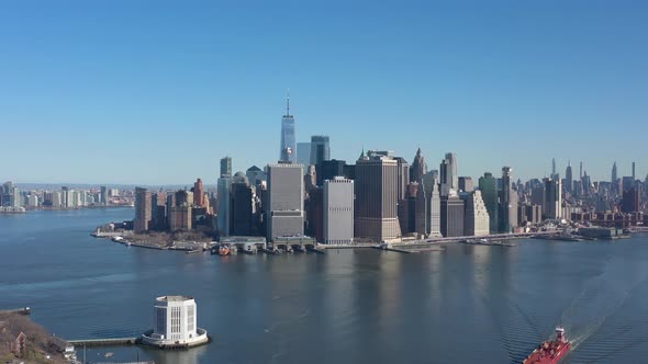 An aerial view of New York harbor on a sunny day with clear blue skies. The drone camera dolly in ov