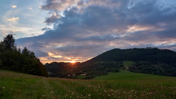 Sunset over the hills on a green meadow  at countryside