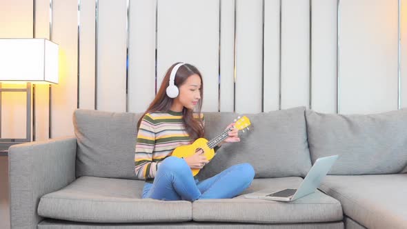 Young asian woman play ukulele