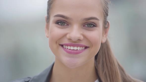 Close-up Portrait of Carefree Confidence Happy Girl Looking at Camera Outdoors. Real People Series