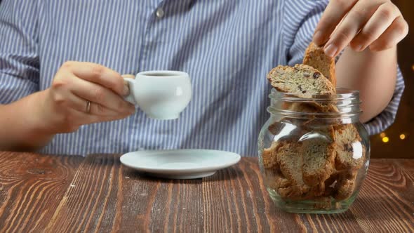 Woman Takes Cantucci Cookies From a Glass Jar and Dips It in the Espresso Coffee