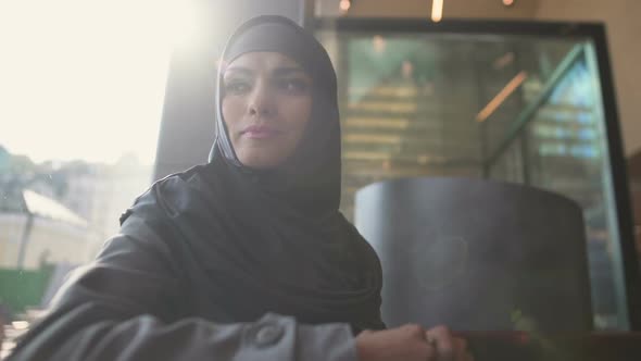 Depressed Arabic Female in Cafe Thinking, Uncertain of Decision, Insecurities